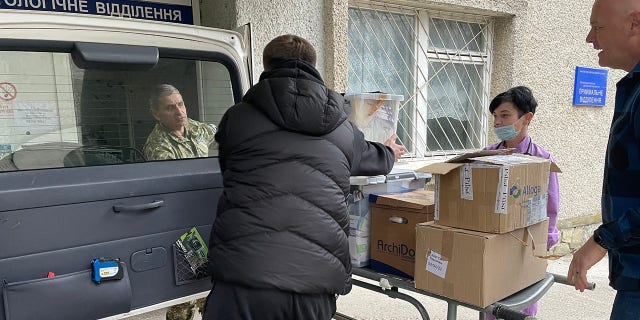 Dr. Daniel Smith assists with the unloading of medical supplies to a hospital in Ukraine. 