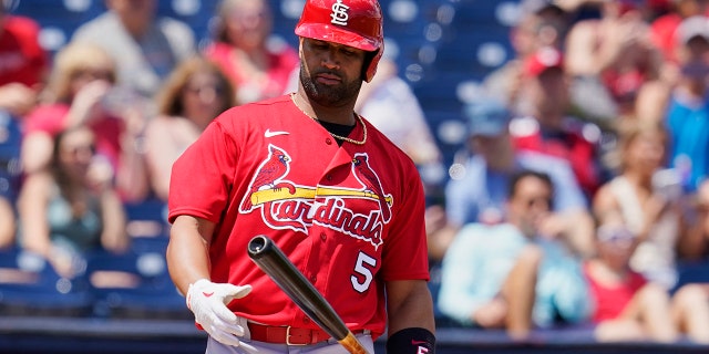 St. Louis Cardinals' Albert Pujols (5) looks at his bat in the first inning of a spring training baseball game against the Washington Nationals, Wednesday, March 30, 2022, in West Palm Beach, Fla.