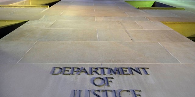 The Department of Justice headquarters building in Washington is photographed early in the morning. Twelve people, including three U.S. Army soldiers, are accused in a large-scale gun trafficking ring that prosecutors allege supplied nearly 100 guns to gang members in Chicago.