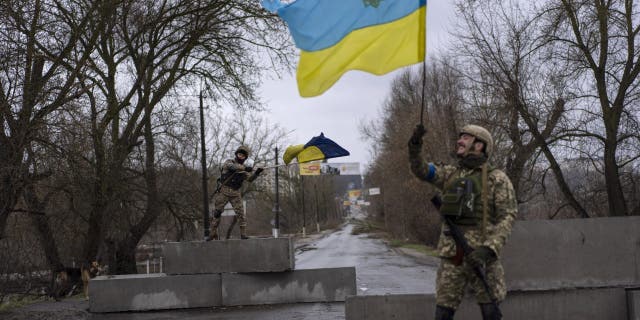 Ukrainian soldiers celebrate at a check point in Bucha, on the outskirts of Kyiv, Ukraine, Sunday, April 3, 2022. 