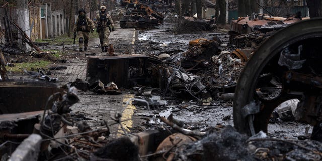 Soldiers walk amid destroyed Russian tanks in Bucha on the outskirts of Kyiv, Ukraine, April 3, 2022.