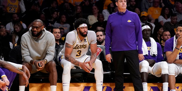 Los Angeles Lakers forward LeBron James, left, sits on the Bech next to forward Anthony Davis as head coach Frank Vogel stands by during the second half of an NBA basketball game against the Denver Nuggets Sunday, April 3, 2022, in Los Angeles.