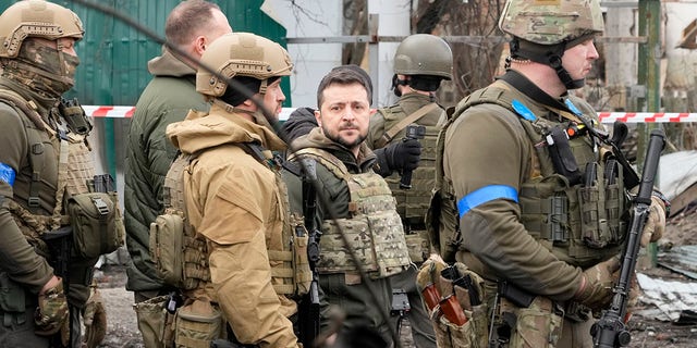 Ukrainian President Volodymyr Zelenskyy examines the site of a recent battle in Bucha, close to Kyiv, Ukraine, Monday, Apr. 4, 2022.