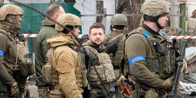 Ukrainian President Volodymyr Zelenskyy examines the site of a recent battle in Bucha, close to Kyiv, Ukraine, Monday, Apr. 4, 2022. 