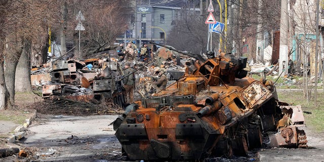 Ukrainian soldiers examine destroyed Russian military vehicles following a battle in Bucha, close to Kyiv, Ukraine, Monday, April 4, 2022. Russia is facing a fresh wave of condemnation after evidence emerged of what appeared to be deliberate killings of dozens if not hundreds of civilians in Ukraine. 