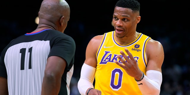Los Angeles Lakers guard Russell Westbrook (0) talks to referee Derrick Collins (11) during the second half of the team's NBA basketball game against the Phoenix Suns, Tuesday, April 5, 2022, in Phoenix. The Suns won 121-110.