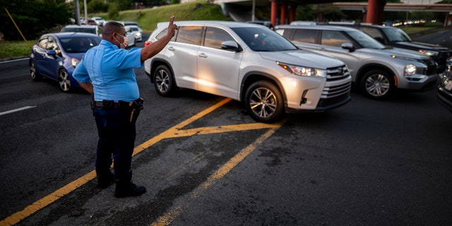 A police officer directs cars along RH Tood Avenue after a crash near an intersection during a blackout in San Juan, Puerto Rico, early Thursday, April 7, 2022. 