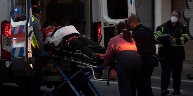 First responders give medical assistance to a driver on R.H. Tood Avenue after a car crash near an intersection during a blackout in San Juan, Puerto Rico, early Thursday, April 7, 2022. 