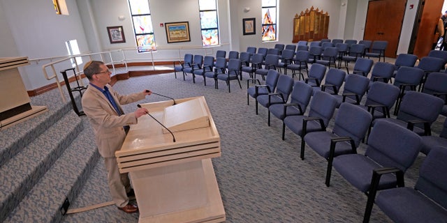 Rabbi Charlie Cytron-Walker adjusts the microphones while testing the sound system at Congregation Beth Israel in Colleyville, Texas, Thursday, April 7, 2022.