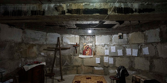 A makeshift chapel in the bomb shelter nuns have prepared to take shelter in when air raids go off, at the Hoshiv Women's Monastery, where nuns have been taking in internally displaced people fleeing the war, in Ivano-Frankivsk region, western Ukraine, Wednesday, April 6, 2022. Mattresses, blankets and benches also line the basement. But even when there are no sirens, children happily use the cavernous underground space. 
