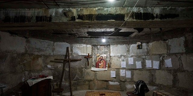 A makeshift chapel in the bomb shelter nuns have prepared to take shelter in when air raids go off, at the Hoshiv Women's Monastery, where nuns have been taking in internally displaced people fleeing the war, in Ivano-Frankivsk region, western Ukraine, Wednesday, April 6, 2022. Mattresses, blankets and benches also line the basement. But even when there are no sirens, children happily use the cavernous underground space. 