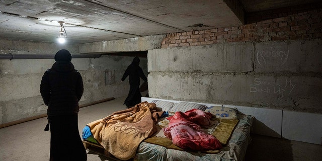 Nuns walk in the basement they have prepared to take shelter when air raids go off, at the Hoshiv Women Monastery, where nuns have been taking in internally displaced people fleeing the war, in Ivano-Frankivsk region, western Ukraine, Wednesday, April 6, 2022.