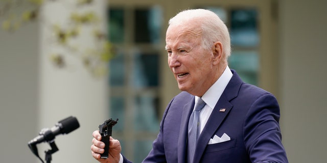 President Joe Biden holds pieces of a 9mm pistol as he speaks in the Rose Garden of the White House in Washington, Maandag, April 11, 2022. 