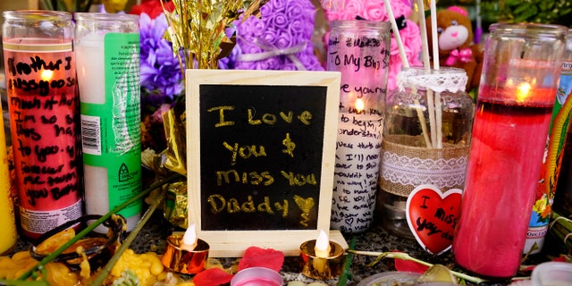 A message left for one of the victims of a recent mass shooting sits among flowers and candles at a memorial in Sacramento, Calif., Saturday, April 9, 2022.
