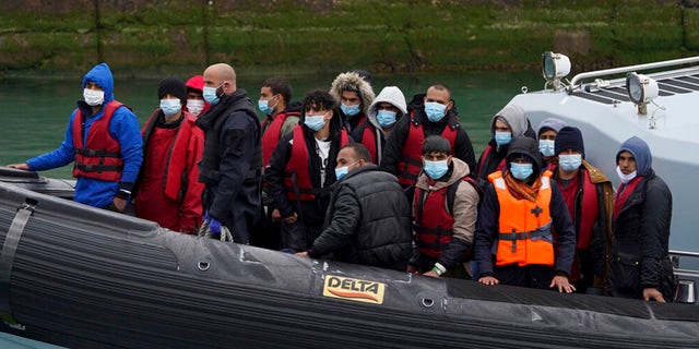 A group of people believed to be migrants is taken to Dover, Kent, on a Border Force ship.