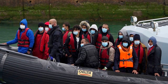 A group of people believed to be migrants is taken to Dover, Kent, on a Border Force ship.