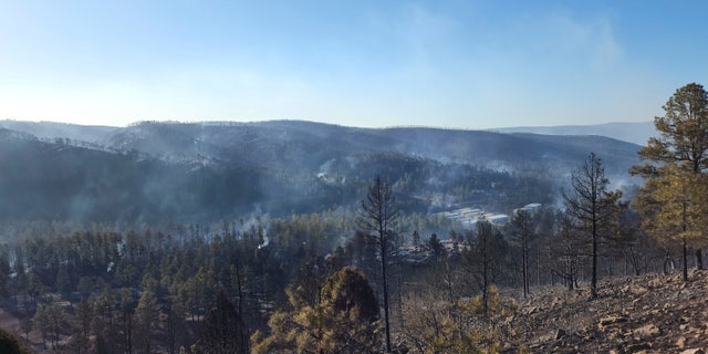 Smoke rises along a hillside in the Village of Ruidoso, N.M., on Wednesday, April 13, 2022.