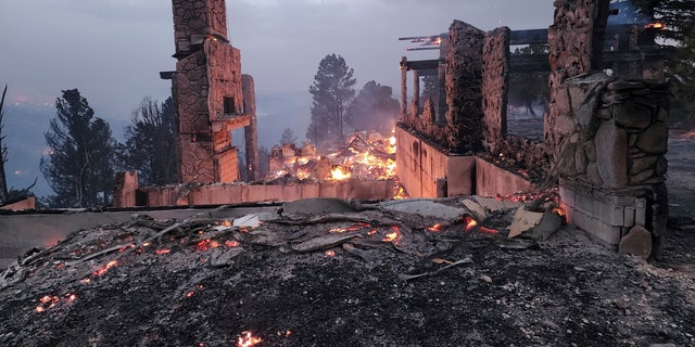 The remains of a home left after a wildfire spread through the Village of Ruidoso, New Mexico, on Wednesday, April 13, 2022.