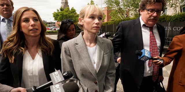 Sherri Papini of Redding walks to the federal courthouse accompanied by her attorney, William Portanova, right, in Sacramento, Calif., Wednesday, April 13, 2022. 
