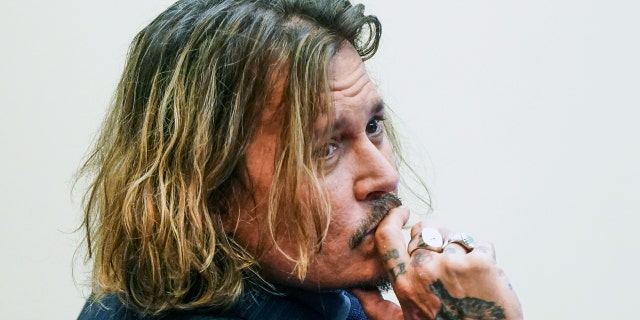 US actor Johnny Depp looks over his shoulder as he sits in the courtroom during the 50 million US dollars Depp vs Heard defamation trial at the Fairfax County Circuit Court in Fairfax, Virginia.