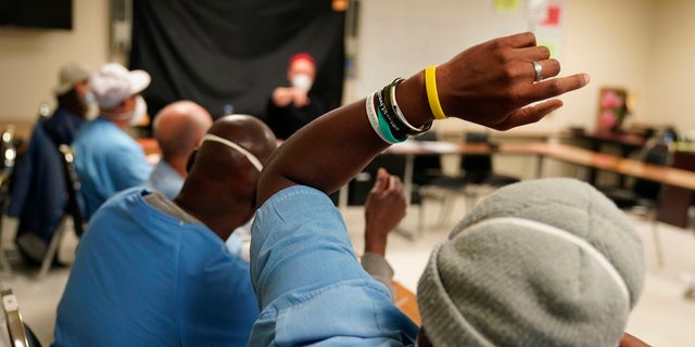 An incarcerated student raises his hand during a Mount Tamalpais College English class.