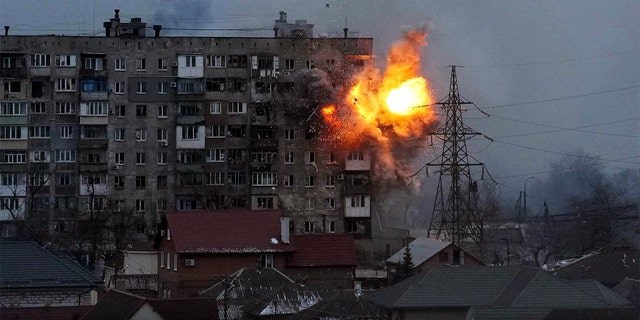 An explosion is seen in an apartment building after a Russian army tank fire in Mariupol, Ukraine, Friday, March 11, 2022. 