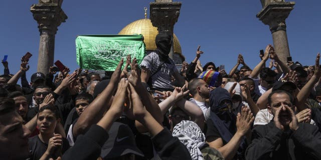 Palestinians chant slogans and wave Hamas flags during a protest against Israel in Jerusalem's Old City, Friday, April 15, 2022. 