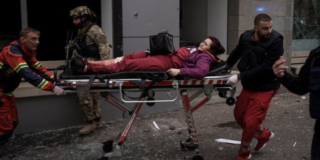 A woman is taken to an ambulance after being injured in a Russian bombardment in Kharkiv, Ukraine, Sunday, April 17, 2022. (AP Photo/Felipe Dana)