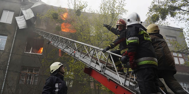 Firefighters work to put out a fire in a building after a Russian attack in Kharkiv, Ukraine, Sunday, April 17, 2022. (AP Photo/Andrew Marienko)