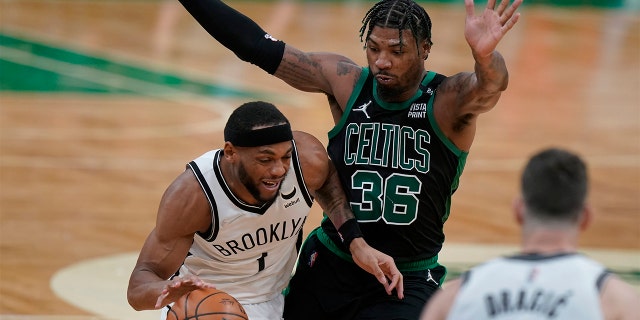 Brooklyn Nets forward Bruce Brown (1) drives with the ball as Boston Celtics guard Marcus Smart (36) defends in the second half of Game 1 of an NBA basketball first-round Eastern Conference playoff series, Sunday, April 17, 2022, in Boston. The Celtics won 115-114.