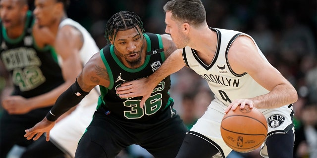 Boston Celtics guard Marcus Smart (36) defends as Brooklyn Nets guard Goran Dragic, of Slovenia, right, looks for an opening in the first half of Game 1 of an NBA basketball first-round Eastern Conference playoff series, Sunday, April 17, 2022, in Boston. The Celtics won 115-114.
