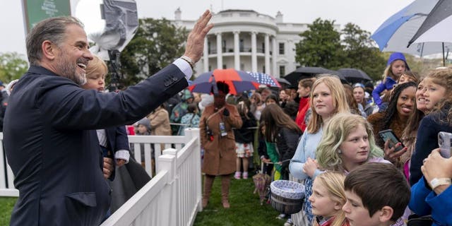 Hunter Biden, left, the son of President Joe Biden, holds his son, Beau Biden, and waves to people in the audience during the White House Easter Egg Roll on the South Lawn of the White House, Monday, April 18, 2022.