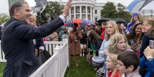 Hunter Biden, left, the son of President Joe Biden, holds his son, Beau Biden, and waves to people in the audience during the White House Easter Egg Roll on the South Lawn of the White House, Monday, April 18, 2022, in Washington. (AP Photo/Andrew Harnik)