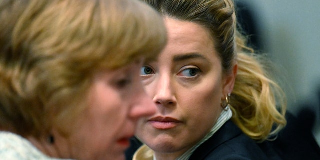 Attorney Elaine Bredehoft (L) and US actress Amber Heard look on during a trial in the Fairfax County Circuit Courthouse in Fairfax, Virginia, on April 19, 2022.