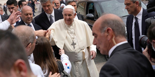 Papst Franziskus begrüßt eine Gruppe französischer Pilger am Ende seiner wöchentlichen Generalaudienz auf dem Petersplatz im Vatikan am Mittwoch, den 20. April 2022.