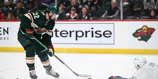 Vancouver Canucks defenseman Luke Schenn (2) slides to the ice to try to block a shot by Minnesota Wild left wing Kevin Fiala (22) during the first period of an NHL hockey game Thursday, April 21, 2022, in St. Paul, Minn. 