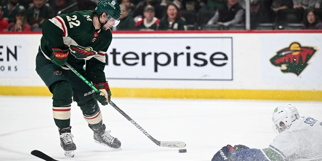 Vancouver Canucks defenseman Luke Schenn (2) slides to the ice to try to block a shot by Minnesota Wild left wing Kevin Fiala (22) during the first period of an NHL hockey game Thursday, April 21, 2022, in St. Paul, Minn.