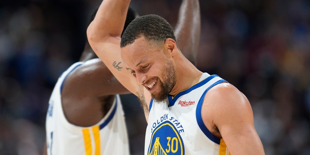 Golden State Warriors guard Stephen Curry congratulates forward Draymond Green near the end of Game 3 of the team's NBA basketball first-round Western Conference playoff series against the Nuggets Thursday, April 21, 2022, in Denver.