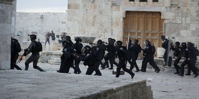 Israeli police enter the Al Aqsa Mosque compound where they clashed with Palestinian protesters following early morning prayers in Jerusalem's Old City, Friday, April 22, 2022.