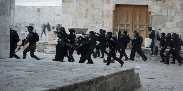 Israeli police enter the Al Aqsa Mosque compound where they clashed with Palestinian protesters following early morning prayers in Jerusalem's Old City, Friday, April 22, 2022.