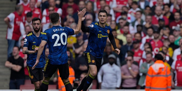 Manchester United's Cristiano Ronaldo celebrates after scoring his team's first goal in the Arsenal-Manchester United UK Premier League football match on Saturday, April 23, 2022 at Emirates Stadium in London. .. 