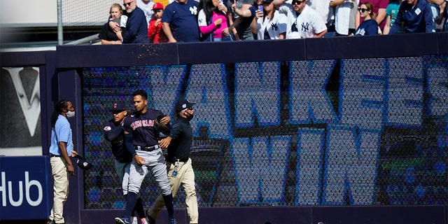 Cleveland Guardians right fielder Oscar Mercado is restrained during an altercation with fans after a game against the New York Yankees Saturday, April 23, 2022, In New York. The Yankees won 5-4. 