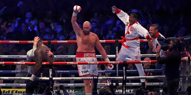Britain's Tyson Fury, center, celebrates after beating Britain's Dillian Whyte during their WBC heavyweight title boxing fight at Wembley Stadium in London, Saturday, April 23, 2022.