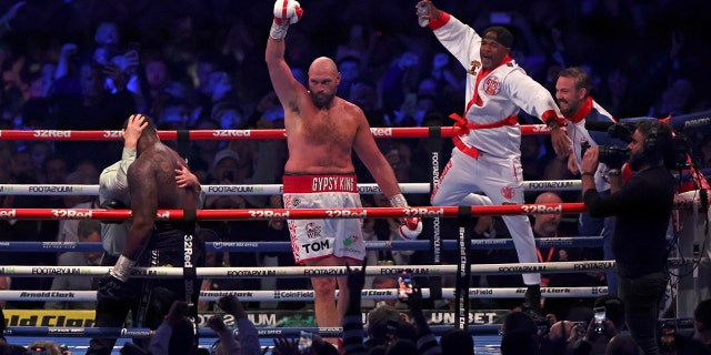 Britain's Tyson Fury, center, celebrates after beating Britain's Dillian Whyte during their WBC heavyweight title boxing fight at Wembley Stadium in London, Saturday, April 23, 2022.