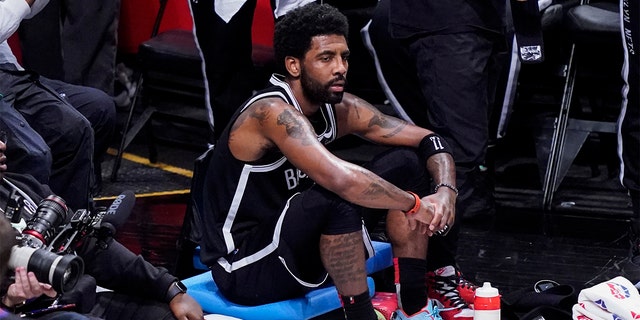 Brooklyn Nets guard Kyrie Irving sits on the baseline during the first half of Game 3 of a first-round playoff series against the Boston Celtics, Saturday, April 23, 2022, in New York. 