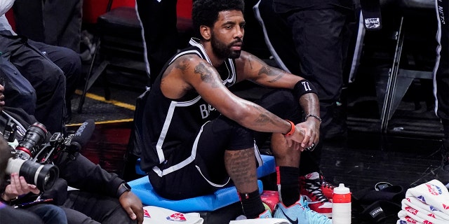 Brooklyn Nets guard Kyrie Irving sits on the baseline in the first half of Game 3 of a playoff series in the first round against the Boston Celtics, Saturday, April 23, 2022 in New York.