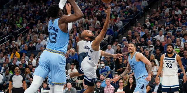 Minnesota Timberwolves guard Jordan McLaughlin, center, moves up for a shot between Memphis Grizzlies attacker Jaren Jackson Jr., left, and Grizzlies attacker Brandon Clarke, right, during the second half in Game 4 of a first-round playoff series Saturday April 23, 2022, in Minneapolis.