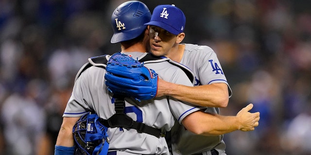 Los Angeles Dodgers starting pitcher Walker Buehler, right, celebrates his complete three-stroke game with catcher Will Smith after a baseball game against the Arizona Diamondbacks on Monday, April 25, 2022 in Phoenix. The Dodgers defeated the Diamondbacks 4-0.