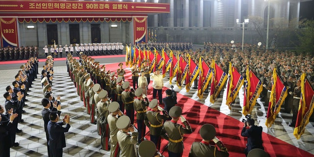 In this photo provided by the North Korean government, North Korean leader Kim Jong Un, center, with his wife Ri Sol Ju reviews an honor guard during a military parade to mark the 90th anniversary of North Korea's army at the Kim Il Sung Square in Pyongyang, North Korea Monday, April 25, 2022. (Korean Central News Agency/Korea News Service via AP)