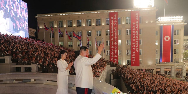 In this photo provided by the North Korean government, North Korean leader Kim Jong Un, with his wife Ri Sol Ju, acknowledges the audience during a military parade to mark the 90th anniversary of North Korea's army at the Kim Il Sung Square in Pyongyang, North Korea Monday, April 25, 2022. (Korean Central News Agency/Korea News Service via AP)